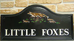 The black background of this Lancaster sign with the fox and her cubs depict night time activities.  The white Times lettering provide an eye-catching contrast