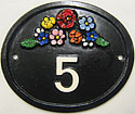 Trinity 1 number plaque in black with brightly painted flower spray above a white number