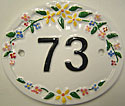 A white Trinity 2 number plaque displaying black numerals